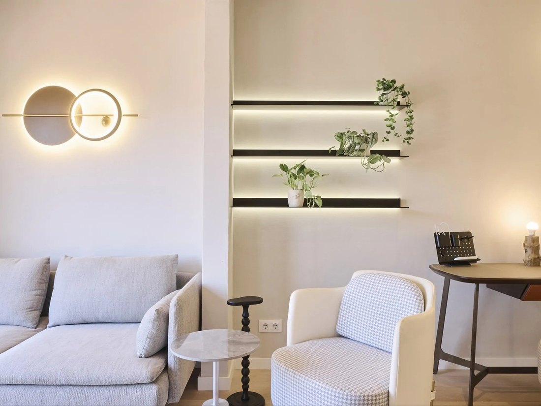 Salón de un piso gestionado por MyRentalHost en Barcelona, con estantes iluminados y plantas