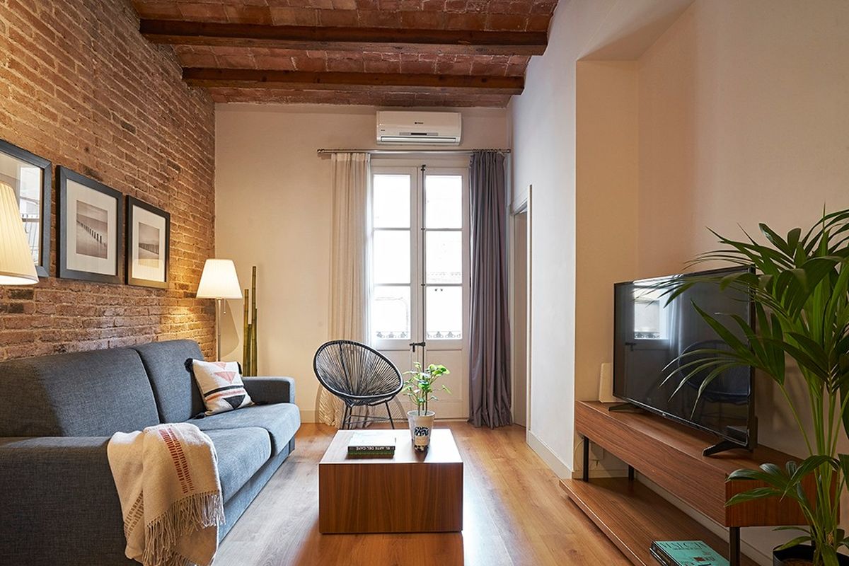 Salón con ladrillo visto y bóveda catalana en un piso gestionado por MyRentalHost en Barcelona